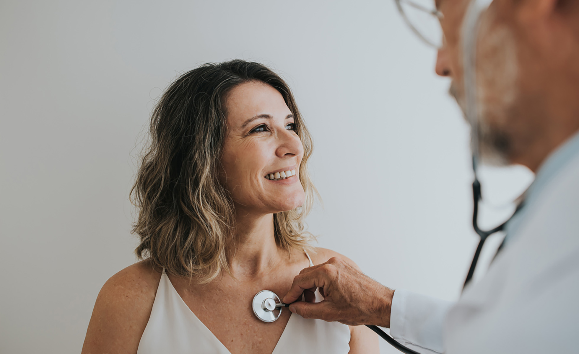 a photo of a doctor using a stethoscope on a patient