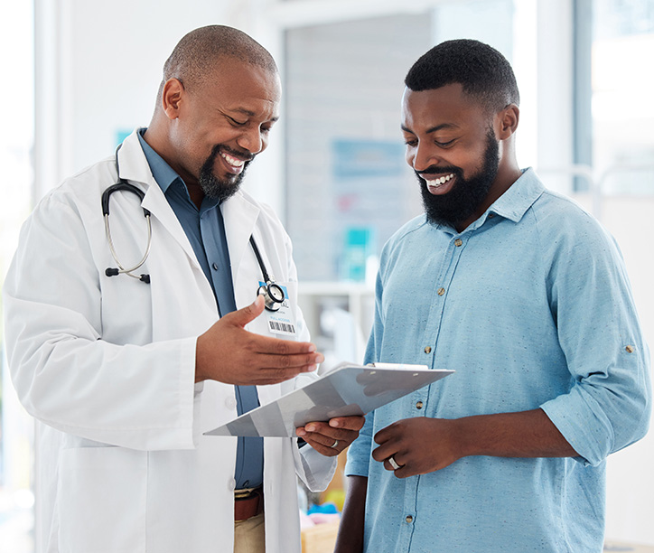 A doctor and male patient discuss results on a tablet