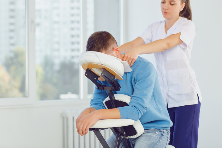 a picture of a therapist and patient getting a chair massage